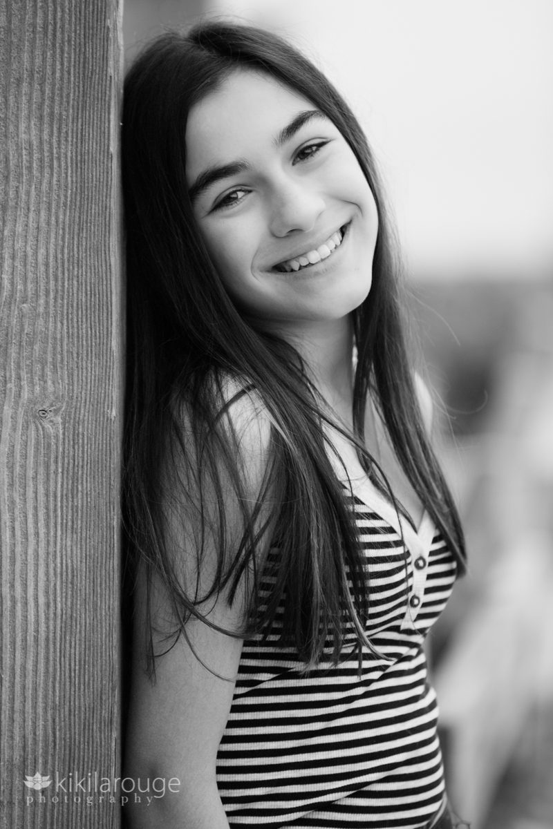 Teen girl leaning on wood post at Sandy Point beach