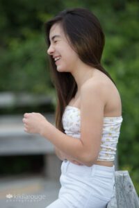Teen girl with long brown hair laughing in profile
