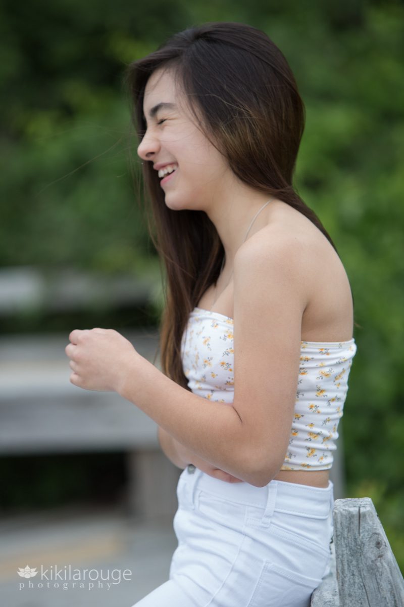 Teen girl with long brown hair laughing in profile