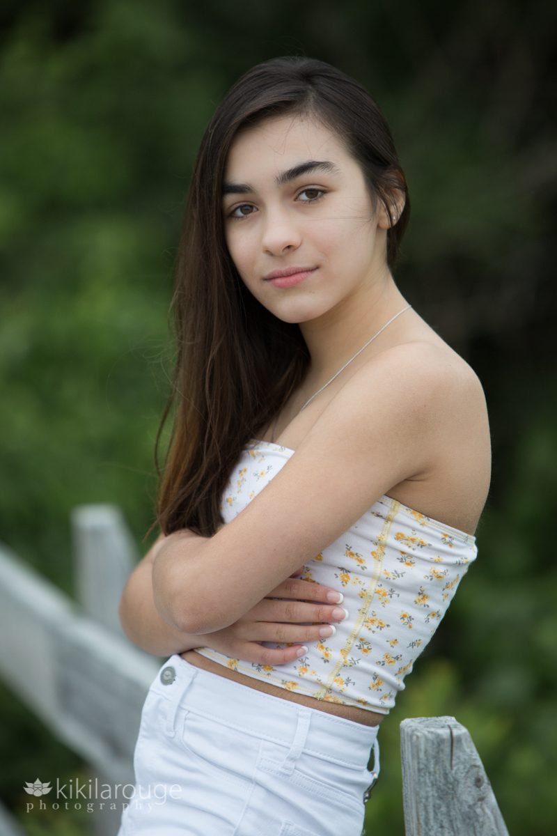 Teen girl with arms folded in white jeans