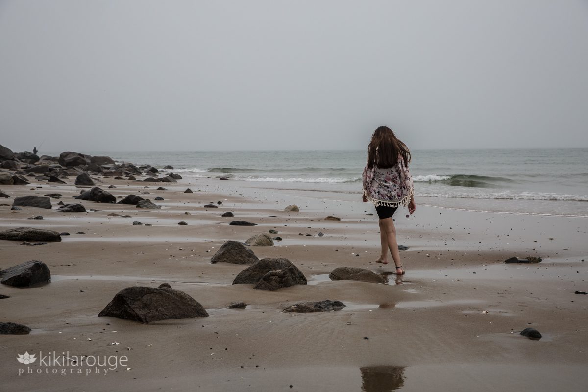 You girl walking down desolate beach at Sandy Point