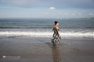 Young girl long flowing black dress by water's edge