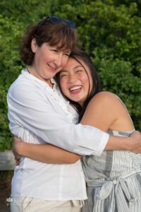 Teen girl laughing and smiling hugging her mom