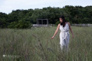 Girl in long white striped jumper in dune field