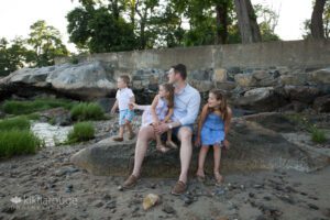 Dad with three kids at baech looking out on the water