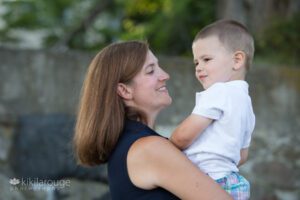 Mom in blue sleeveless dress holding toddler boy