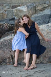 Young girl kissing her Mom on cheek