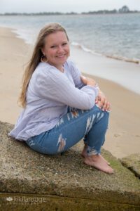 Senior Girl Portrait in purple shirt with jeans at beach