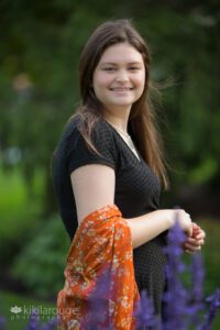 Portrait of teen girl in black dress with orange wrap