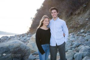 Cute teen couple together on rocks at Sandy point beach