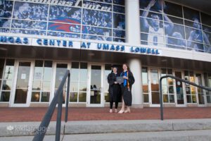 Two young woman in graduation robes and diploma