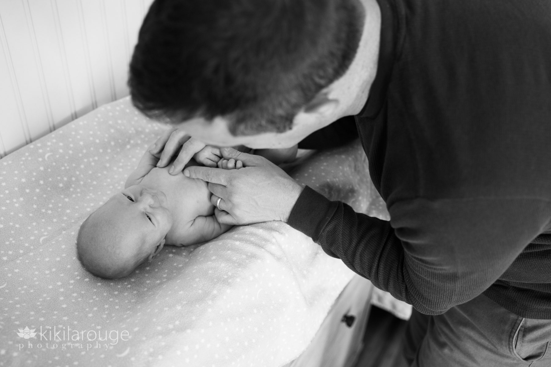 Dad changing a smiling baby girl's diaper