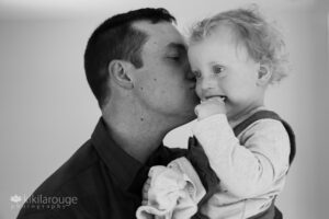 Dad kissing toddler boy on cheek