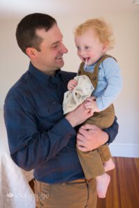 Dad with toddler boy with lollipop and blank smiling together