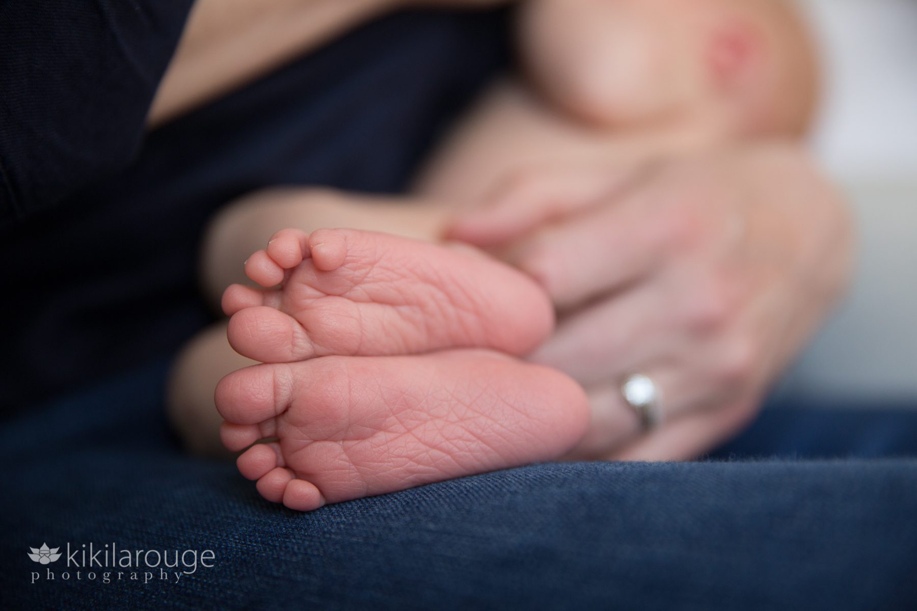 Newborn baby's feet close up while breastfeeding