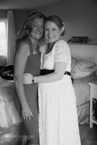 Pregnant bride hugging her mom in bedroom