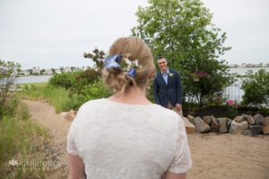 Groom seeing bride for first time on sandy path
