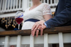 Close up of hands with new wedding rings on porch