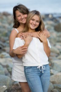 Senior teen girl at beach with Mom hugging