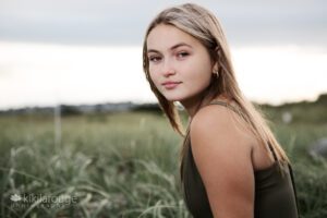Blonde girl in beach dunes looking at camera intently