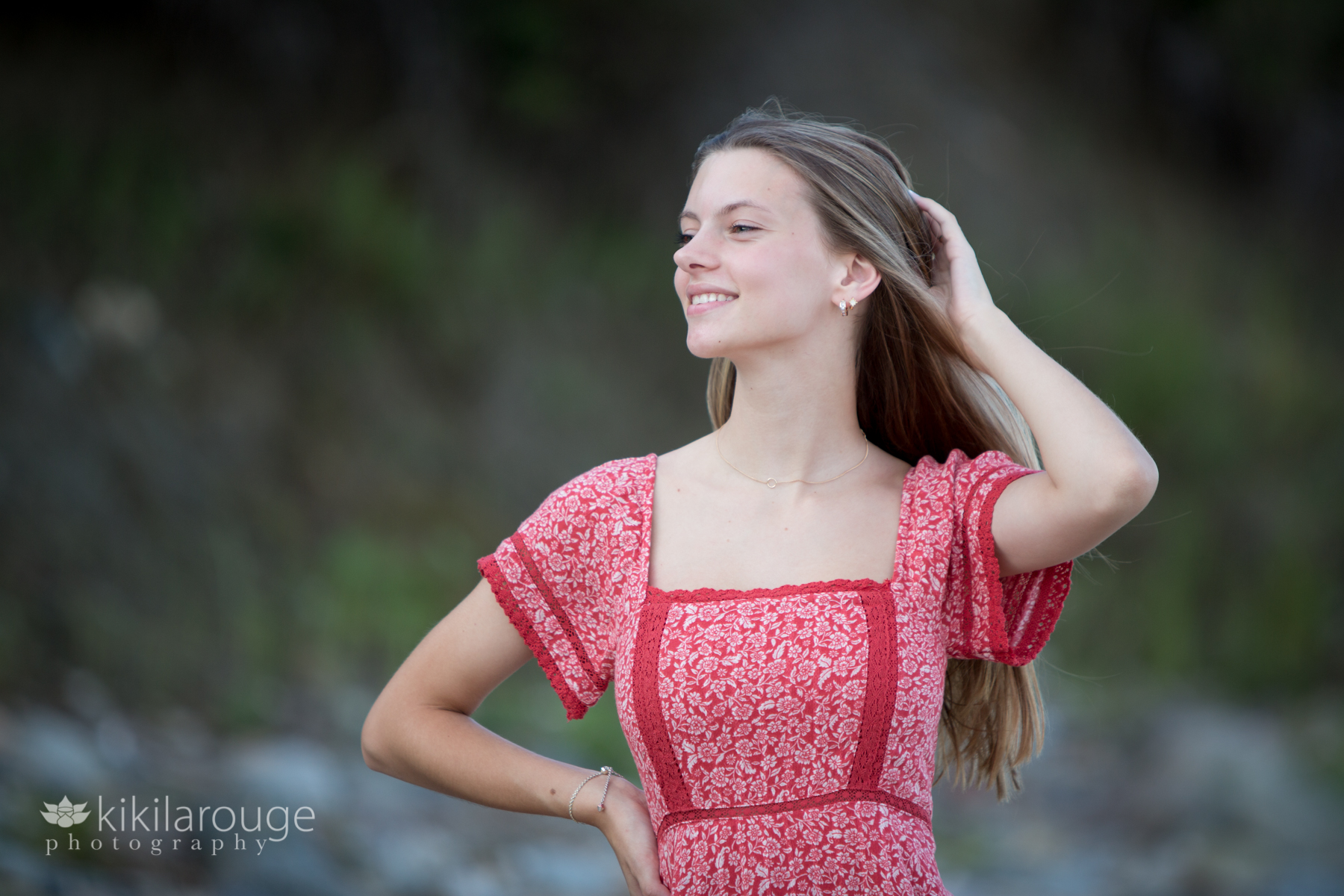 Girl in red dress long blonde hair looking off in distance