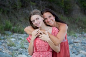 Mom and her teen daughter hugging at beach