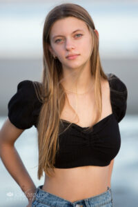 Pretty Senior girl long blonde hair in black half top at beach