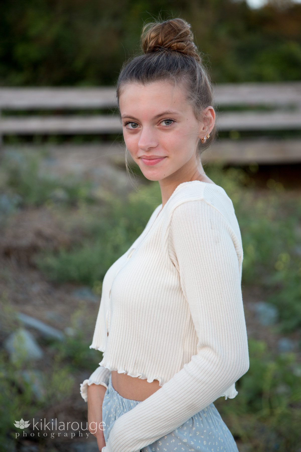 Girl with hair in bun long blue dress and white sweater