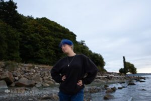 Teen with blue hair on rocky beach
