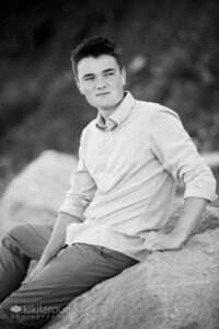 Senior boy sitting on rock at beach