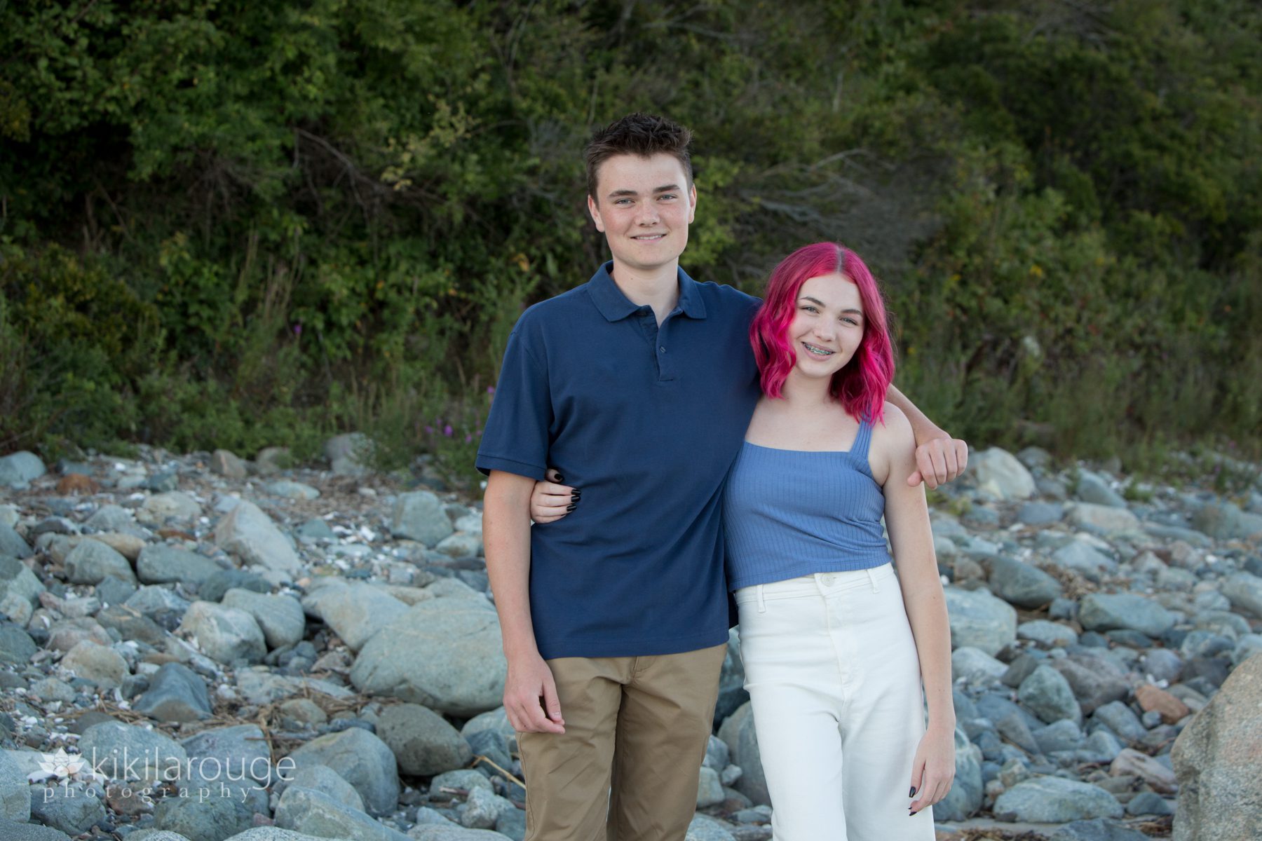 Teen brother and sister at rocky beach