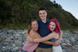 Mom hugging her teen boy and girl at the beach Plum Island