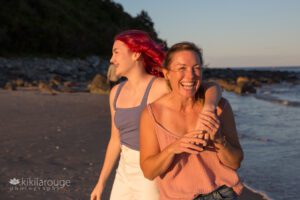 Girl with pink hair laughing and hugging her Mom