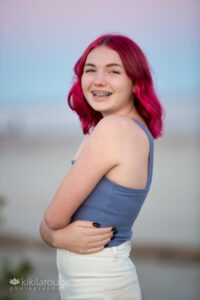 Portrait of young teen girl with bright pink hair at pink sunset