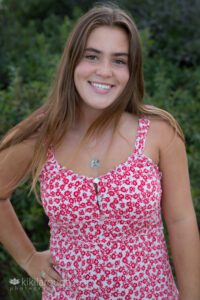 Pretty teen brunette girl in floral red dress hair blowing