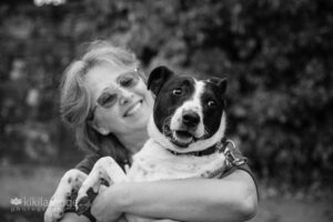 Woman smiling and holding black and white rescue dog