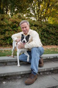 Man yellow shirt jeans hugging cute smiling rescue dog JP Arboretum