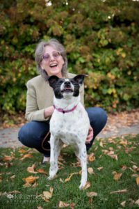 Woman with smile laughing at dog catching a treat