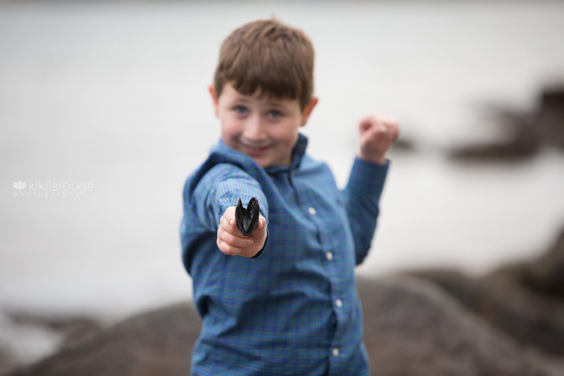 Little boy holding out mussel shell