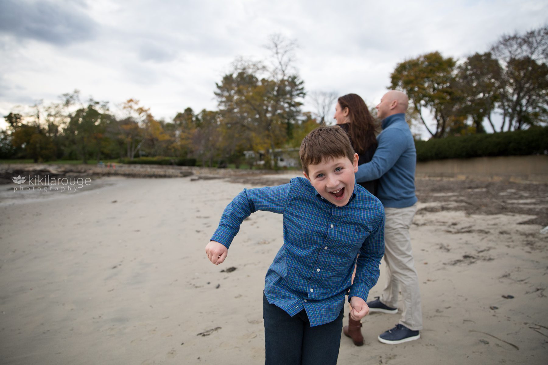 Little boy in blue shirt dancing in front to his parents