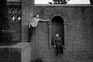 Two boys playing on brick wall