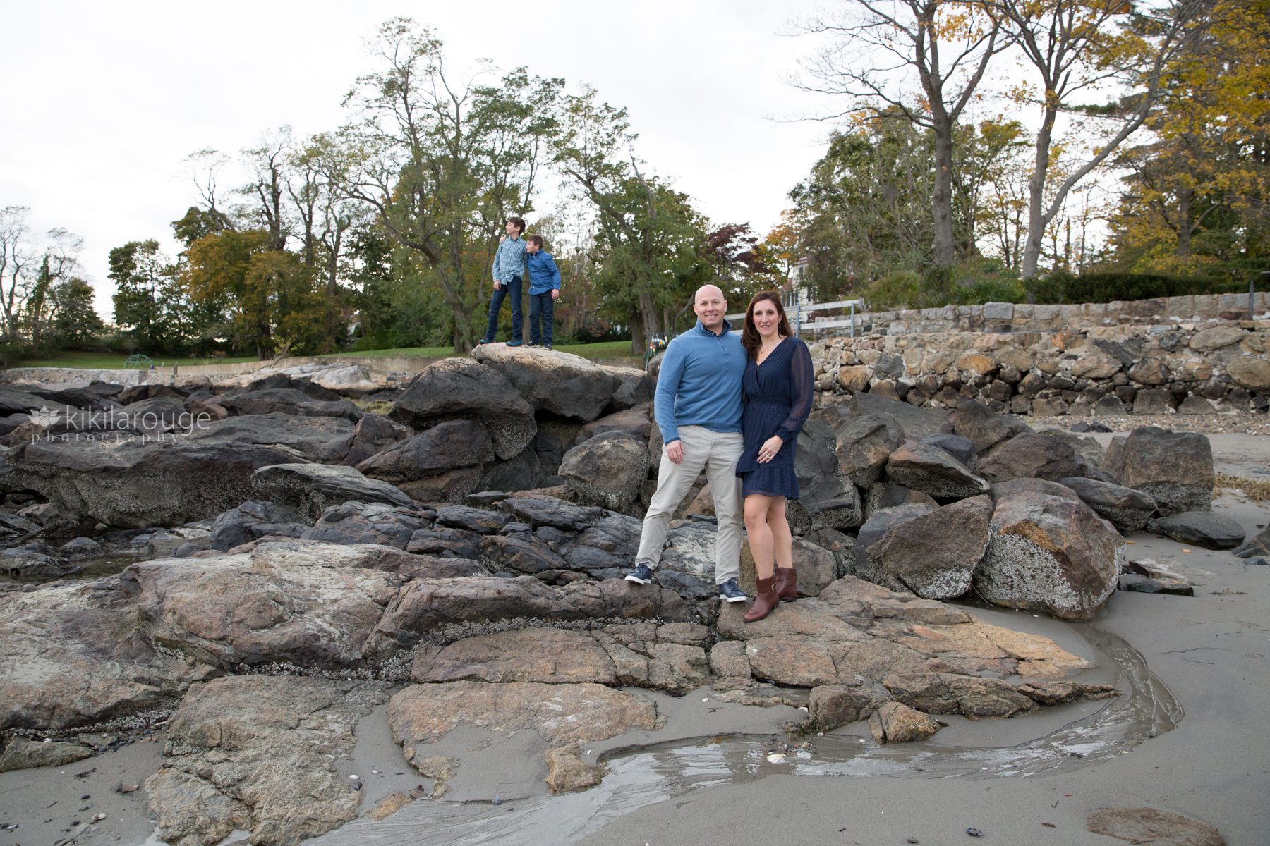 Fall Portrait at rocky beach parents in front boys in backdrop