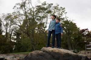 Two brother up on rocks looking off in distance