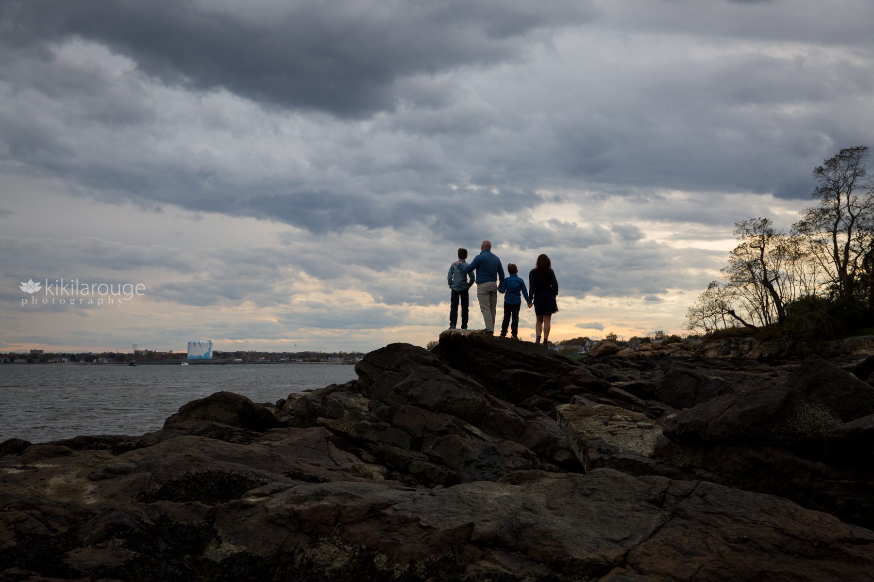 Family Portrait silhouette on rocks with dramatic sunset