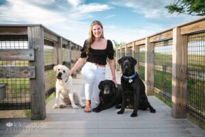 Teen girl on boardwalk with her three lab dogs