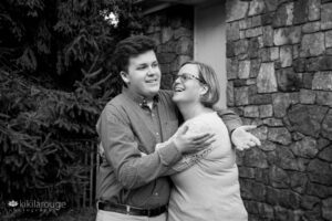 Teen Senior Boy hugging and laughing with his Mom on Senior shoot