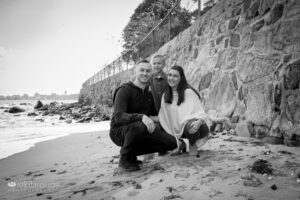 Family portrait in BW on beach with stone wall