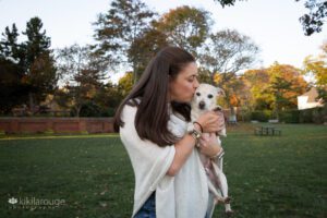 Brunette woman with white Chihuahua rescue mix dog at park