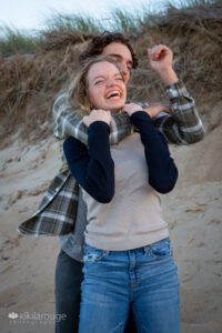 Teen siblings wrestling and laughing at the beach