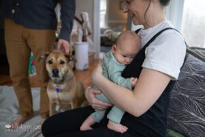 Mom holding baby with Dad and rescue dog to the side